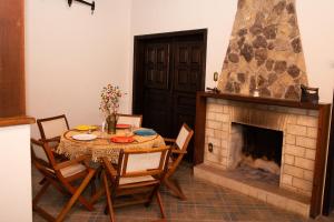 a dining room with a table and a fireplace at Sossego e aconchego ao lado do INHOTIM in Brumadinho