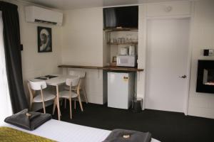 a small kitchen with a table and chairs in a room at Mackenzie Motels in Fairlie