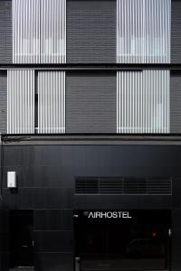 埃普拉特约布里加Airhostel Barcelona Airport 24h的一栋黑白相间的建筑，上面有 atositel 的标志