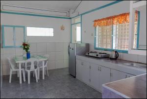 a kitchen with a table and a small table with chairs at Sun House Rental in Mambajao