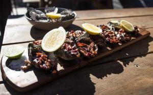 a plate of food on a wooden table with lemon slices at Dampier Mermaid Hotel Karratha in Dampier