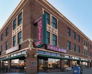 Broken BowArrow Hotel的砖砌建筑,有烧烤和酒吧标志