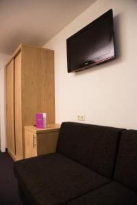 a living room with a couch and a flat screen tv on the wall at Apartments Reiterbäck in Wagrain
