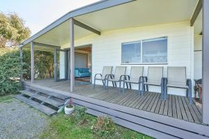 a screened porch with chairs on a house at Far View - Pet Friendly, Free Wifi in Venus Bay