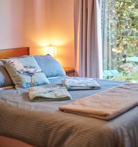 a bed with two towels on it with a window at Far View - Pet Friendly, Free Wifi in Venus Bay