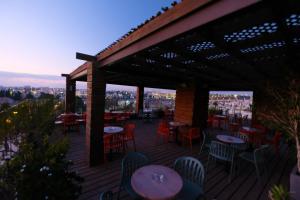 a patio with tables and chairs on a deck at Ritz Hotel in Jerusalem