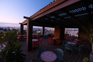 eine Terrasse mit Tischen und Stühlen auf einer Terrasse in der Unterkunft Ritz Hotel in Jerusalem