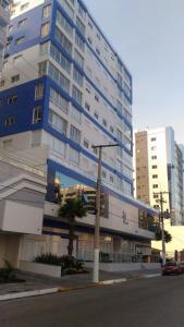 um grande edifício com um semáforo em frente em 02 suítes em Capão da Canoa - Ed Maui em Capão da Canoa