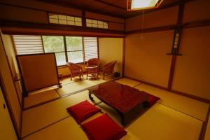 a living room with a table and a couch at Onsen Yado Mizuguchi in Izu