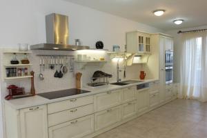 a large kitchen with white cabinets and white appliances at Villa Serena in Mirce