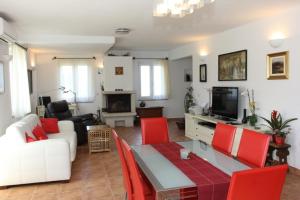 a living room with a white couch and red chairs at Villa Serena in Mirce
