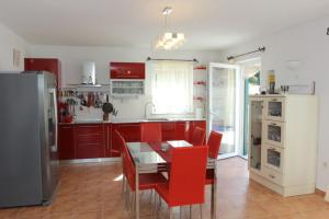 a kitchen with a dining table and red chairs at Villa Serena in Mirce