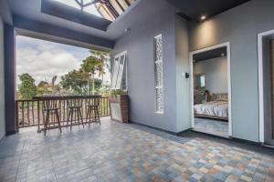 a room with a balcony with a bed and stools at A4k Mua at Ubud in Ubud