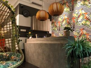 a lobby with a counter and some plants and lights at RedDoorz Hostel at Kallang MRT in Singapore