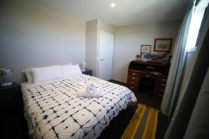 Pedalfish Cottages - Milky Way في تويزل: غرفة نوم بسرير ابيض عليها بجعة
