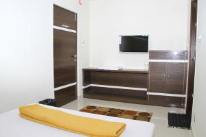 a bathroom with a bed and a television in it at Mp Residency in Kumbakonam