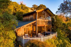 a house with a wrap around porch in the woods at The Wheelhouse Inn in Nelson