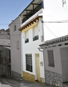 Edificio blanco con puerta y balcón en La CasetA, en La Pobla de Benifassà (Puebla de Benifasar)
