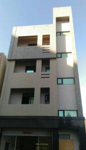 a tall building with many windows on it at Purple Shell Homestay II in Magong