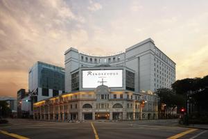 un grande edificio bianco con un grande cartello sopra di Rendezvous Hotel Singapore by Far East Hospitality a Singapore