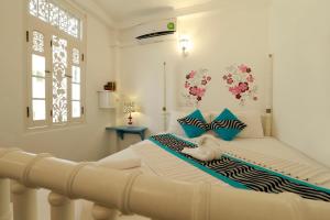 een slaapkamer met een groot wit bed met blauwe kussens bij Fort Heaven - Galle Fort in Galle