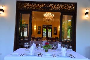 a dining room with a table with a chandelier at Boutique Villa Shanthi in Hikkaduwa