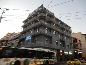 un autobús conduciendo delante de un edificio en Athens Lydia Hotel, en Atenas