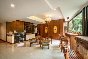 a kitchen with wooden cabinets and a table and chairs at Ingmon House in Chiang Mai