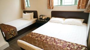 Cette chambre comprend 2 lits et une fenêtre. dans l'établissement B&B Mongkok Hotel, à Hong Kong