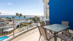 a balcony with a table and chairs and the ocean at Oaks Hervey Bay Resort and Spa in Hervey Bay