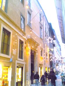 un gruppo di persone che camminano per una strada di città con edifici di Appartamentino Campo dei Fiori a Roma