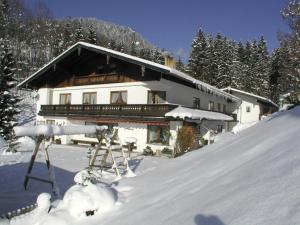 een huis in de sneeuw met sneeuw bij Sportpension Färbinger in Berchtesgaden