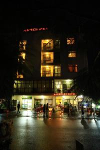 Un bâtiment avec des personnes debout devant lui la nuit dans l'établissement Lakemark Hotel and Tour Service Bahir Dar, à Baher Dar