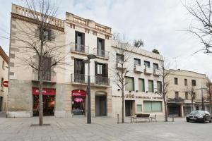 a building on a street with a bench in front of it at Matarolux16 in Mataró
