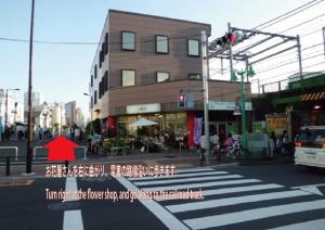 a city intersection with a red arrow on a street at The Shin-Okubo International Hotel in Tokyo