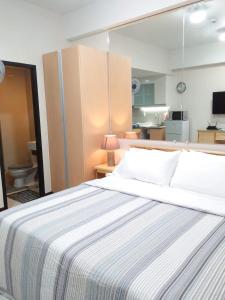 une chambre avec un grand lit et une salle de bain dans l'établissement 101 Newport Boulevard C1, à Manille