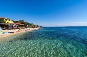 una spiaggia con un gruppo di ombrelloni e l'oceano di Apartments Bakula a Mandre