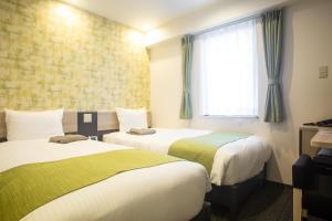 um quarto de hotel com duas camas e uma janela em Kuretake Inn Nankai Sakai-Ekimae em Sakai