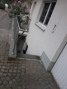 - un bâtiment avec un balcon et une fenêtre avec une plante dans l'établissement Wohnen im Souterrain einer Villa, à Herdecke
