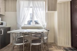 kuchnia ze stołem i krzesłami oraz oknem w obiekcie Apartment Ryadom S Ploshadiu Rynok w Lwowie