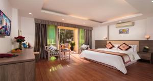 een slaapkamer met een groot bed en een tafel en stoelen bij Van Mieu Hotel in Hanoi