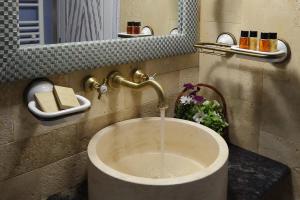 a sink with water coming out of it in a bathroom at Pensiunea Varvara de Bucovina in Gura Humorului