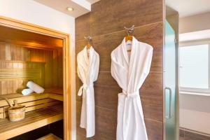 La salle de bains est pourvue d'une douche et de serviettes accrochées au mur. dans l'établissement Hôtel Régent Contades, à Strasbourg