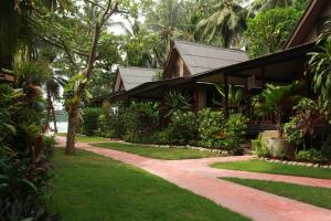 un chemin menant à une maison dans un jardin dans l'établissement Longtail Beach Resort, à Thong Nai Pan Yai