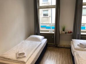 a bedroom with two beds and a window at Downtown City - PrivateRooms in Fürth