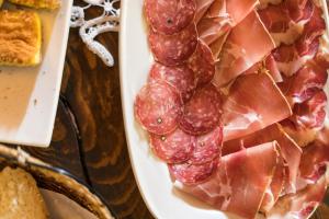 a plate of cured meat and ham on a table at Agriturismo L'Antico Frutto in Premilcuore