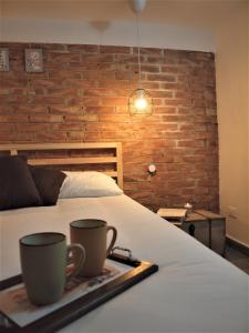 uma cama com duas chávenas numa bandeja em Chalet Gea em Milo