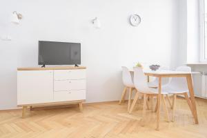 ein Esszimmer mit einem Tisch und einem TV auf einem Schrank in der Unterkunft Bright and modern apartment in the heart of the Old and New Town in Warschau