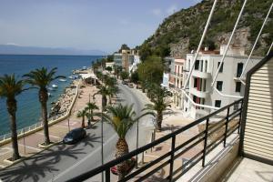 a view of a street with palm trees and the ocean at Petit Palais Hotel in Loutraki