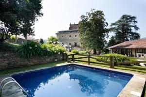 una piscina frente a una casa con una valla en Abba Palacio de Soñanes Hotel, en Villacarriedo